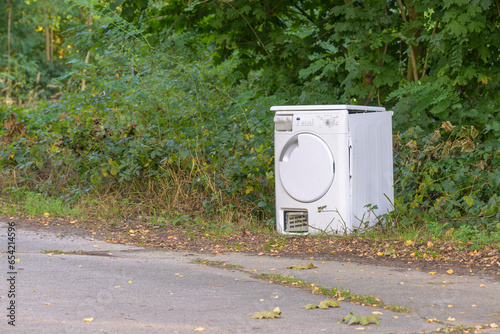 Obraz na płótnie Eine kaputte Waschmaschine wurde einfach am Straßenrand entsorgt w salonie