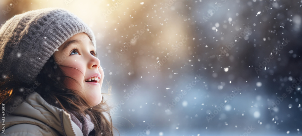 Happy girl in warm clothes in wonder first snowfall of the season, her face glowing, Fun outdoor activities for children in wintertime Happy girl in warm clothes in wonder first snowfall of the season, her face glowing, Fun outdoor activities for children in wintertime