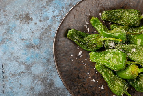 Roasted Blistered Shishito Peppers with Salt on blue grey background. Top view. photo