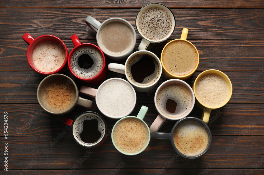 Many different cups with aromatic coffee on wooden table, flat lay Many different cups with aromatic coffee on wooden table, flat lay