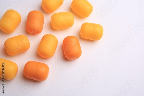 Sveti Vlas, Bulgaria - June 30, , 2023: Orange plastic capsules from Kinder Surprise Eggs on white background, above view and space for text