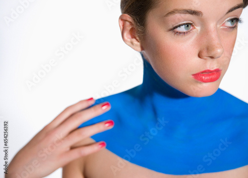 Beautiful young woman with decollete painted with electric blue body paint
 photo