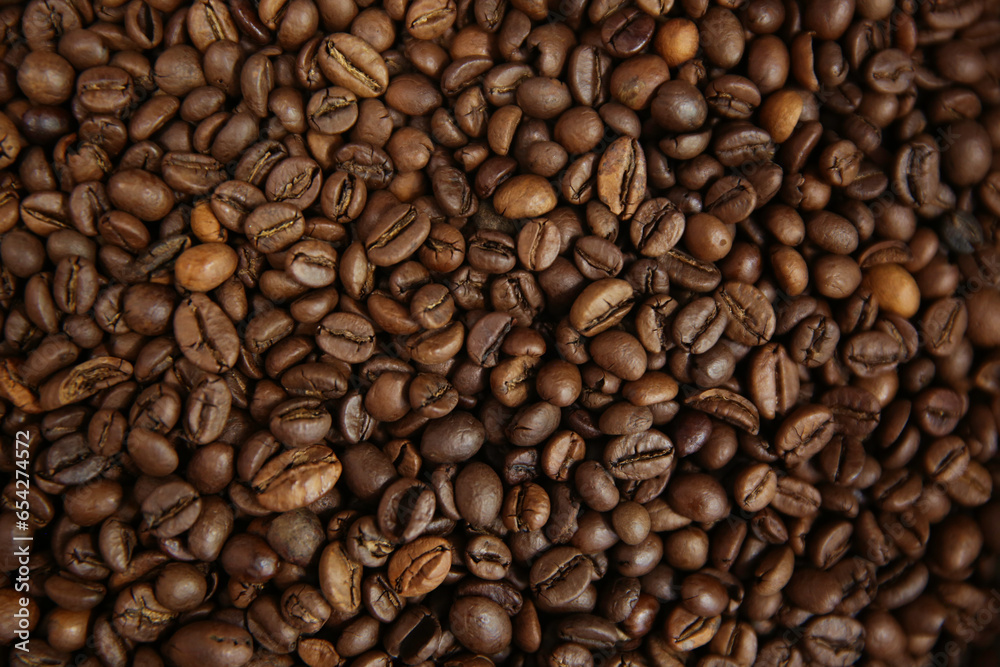 Fototapeta premium Overhead view of backdrop representing halves of dark brown coffee beans. Texture of coffee beans 