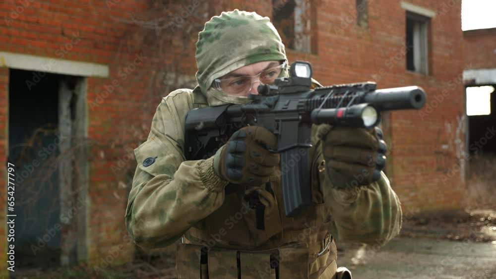 Portrait of a soldier in camouflage military uniform, balaclava and goggles on the background of an old brick wall. The Cold War. Airsoft. Portrait of a soldier in camouflage military uniform, balaclava and goggles on the background of an old brick wall. The Cold War. Airsoft.