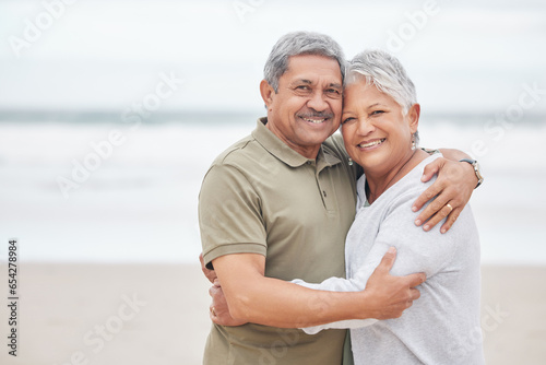 Senior couple, portrait and hug at beach for holiday, vacation or tropical travel in retirement with mockup. Happy man, elderly woman and embrace to relax at ocean, love or loyalty to support partner photo