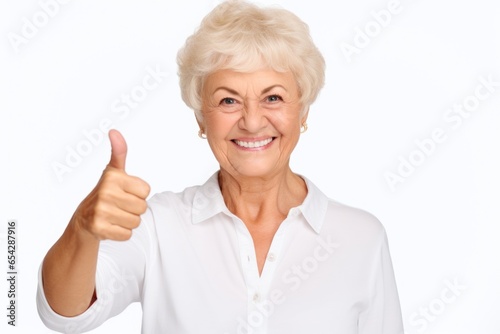 An older woman giving a thumbs up sign. This image can be used to convey approval or positivity.