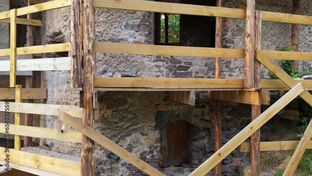 Aging stone castle tower undergoing restoration, encased by hand-built wooden scaffolding. Aging stone castle tower undergoing restoration, encased by hand-built wooden scaffolding.