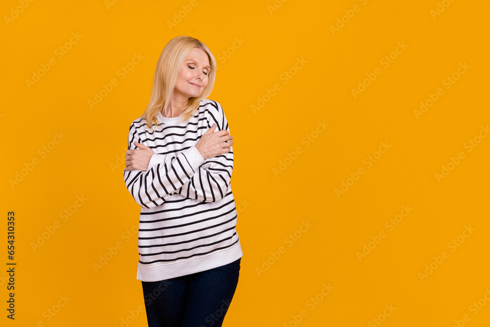 Photo of positive pensioner lady cuddle herself self love appreciation isolated vibrant color background Photo of positive pensioner lady cuddle herself self love appreciation isolated vibrant color background