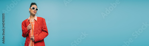 Canvas Print portrait of african american woman in trendy accessories and vibrant outfit posi