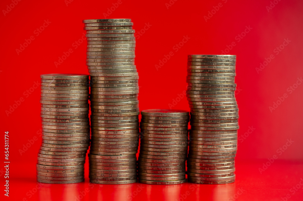 Four piles of golden coins on an orange background. Four piles of golden coins on an orange background.
