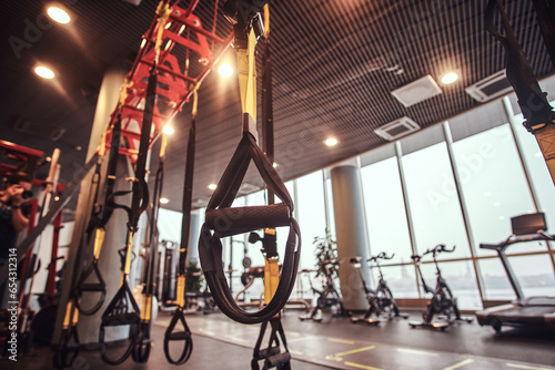 Interior and equipment in the modern gym, close-up view of suspension straps.
