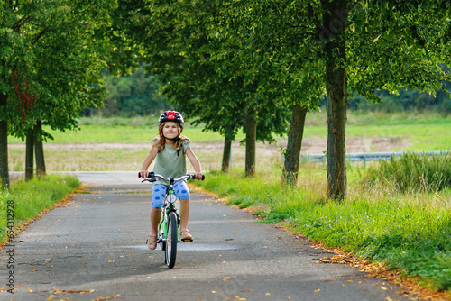 Wallpaper Mural Little preschool girl riding bike. Kid on bicycle outdoors. Happy child enjoying bike ride on her way to school on warm summer day. Preschooler learning to balance on bicycle in safe helmet. Torontodigital.ca