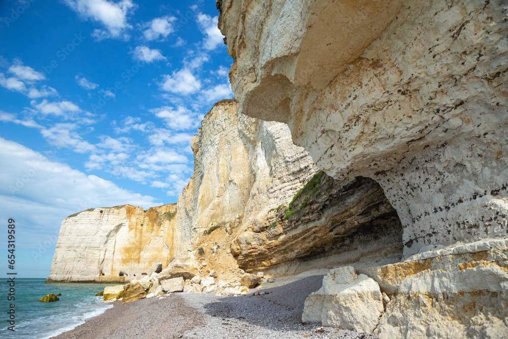 look up angel of the white towering sea cliff with blue sky in Étretat