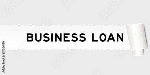 Ripped gray paper background that have word business loan under torn part
