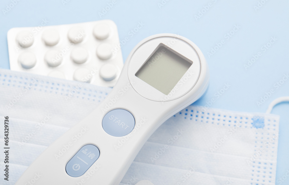 Electronic thermometer on a blue background. Medical things Electronic thermometer on a blue background. Medical things