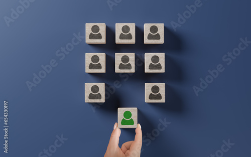 Human resources management and recruitment business hiring concept, corporate hierarchy, recruiter complete team by one leader person. hand selects cube with desired person highlighted in green. photo