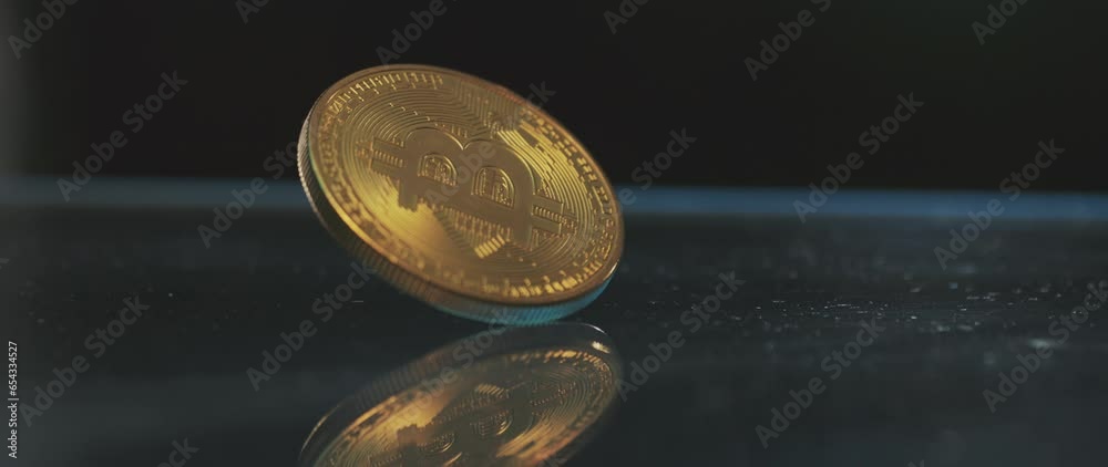 Extreme close-up view of a golden bitcoin physical coin spinning in slow-motion