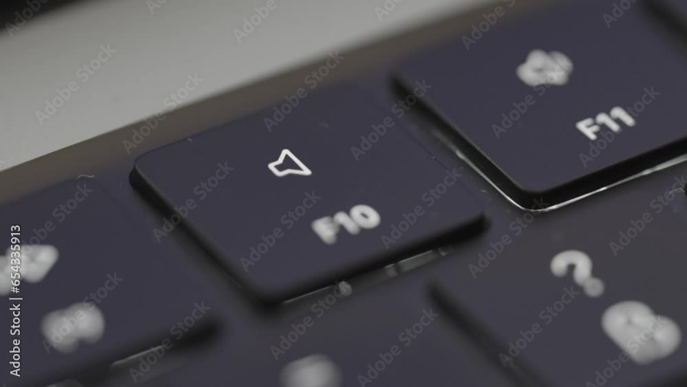 Closeup of mute button on laptop being pressed. Person pressing keys on laptop. Technology footage. Closeup of mute button on laptop being pressed. Person pressing keys on laptop. Technology footage.