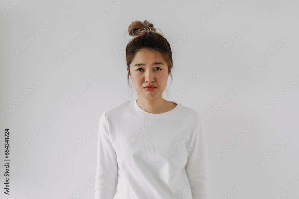 Asian Thai woman sad face, sulking and frowning disappointed look at camera, standing upset isolated on white background in winter.