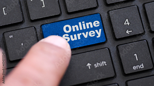 Online survey word on blue enter keypad on laptop