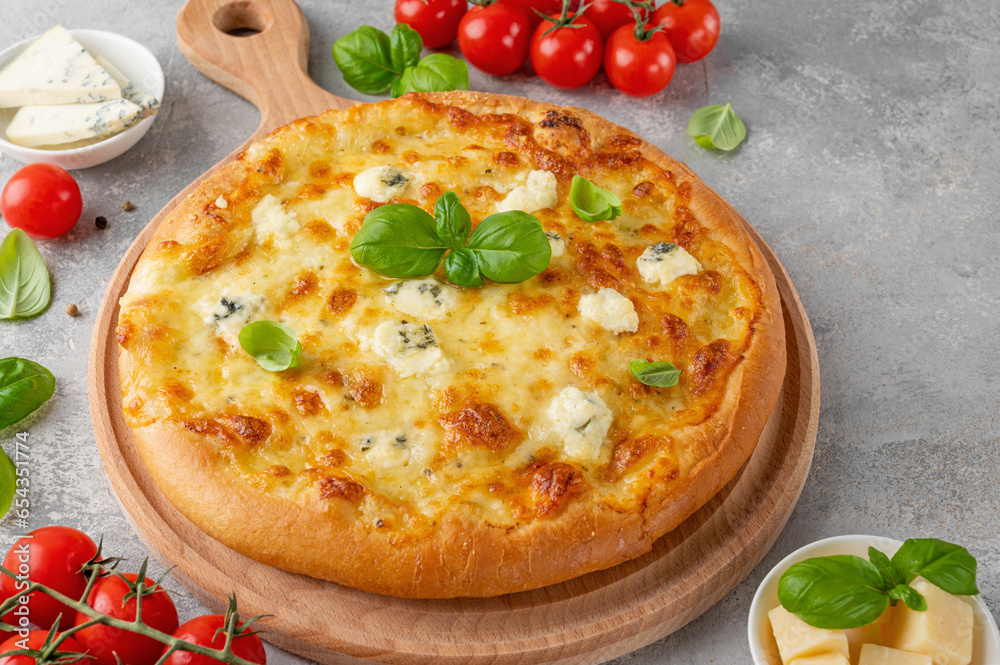 Pizza four cheeses with fresh basil on top on a wooden board on a gray concrete background. Top view, copy space. Pizza four cheeses with fresh basil on top on a wooden board on a gray concrete background. Top view, copy space.