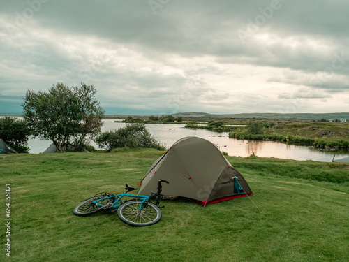 Image of camping side with tents and bicycles at the lake