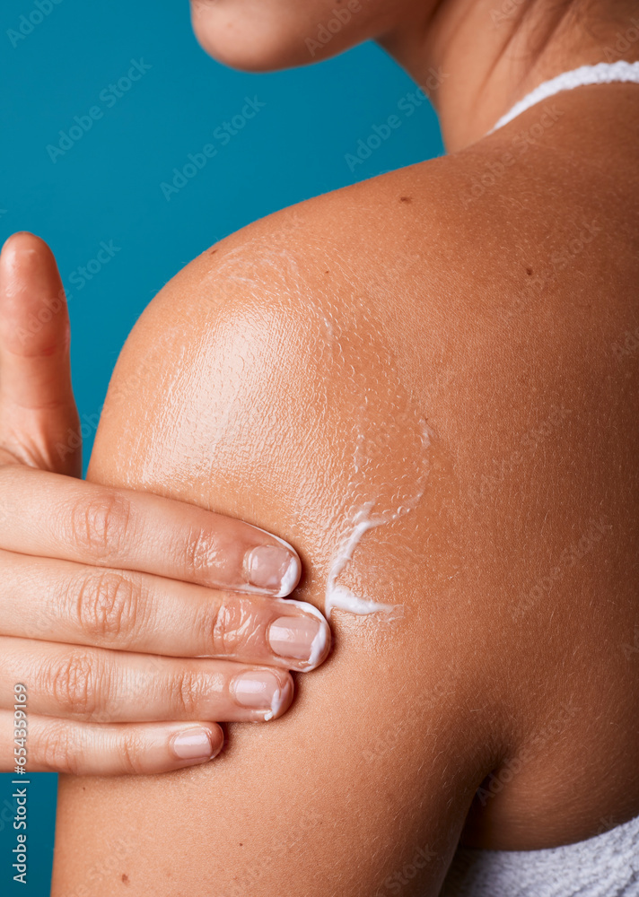 Young woman or girl applying moisturizing lotion cosmetic product cream, self care massage on arm. Pampering sun skin protection. Blue background, fresh atmosphere, copy space. Young woman or girl applying moisturizing lotion cosmetic product cream, self care massage on arm. Pampering sun skin protection. Blue background, fresh atmosphere, copy space.