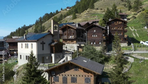 Wallpaper Mural swiss village in the mountains with old wood chalet and a church  Torontodigital.ca