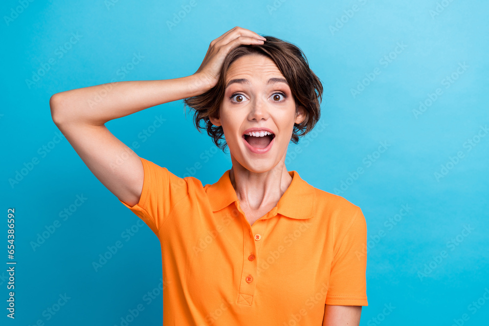 Photo of girly shocked girl dressed orange polo arm head open mouth isolated blue color background Photo of girly shocked girl dressed orange polo arm head open mouth isolated blue color background