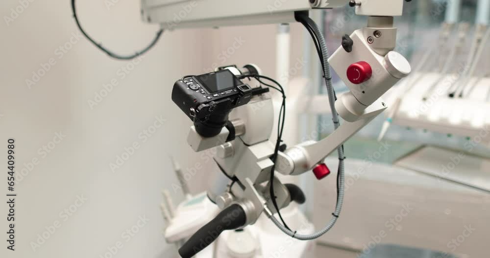 Close-up view of dental microscope indoors in medical clinic without people. Professional equipment with changing magnification and lens in a dental office in a hospital Close-up view of dental microscope indoors in medical clinic without people. Professional equipment with changing magnification and lens in a dental office in a hospital