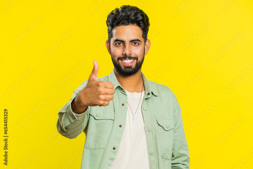Like. Indian man raises thumbs up agrees with something or gives positive reply recommends advertisement likes good idea feedback, celebrating success victory. Guy isolated on studio yellow background Like. Indian man raises thumbs up agrees with something or gives positive reply recommends advertisement likes good idea feedback, celebrating success victory. Guy isolated on studio yellow background