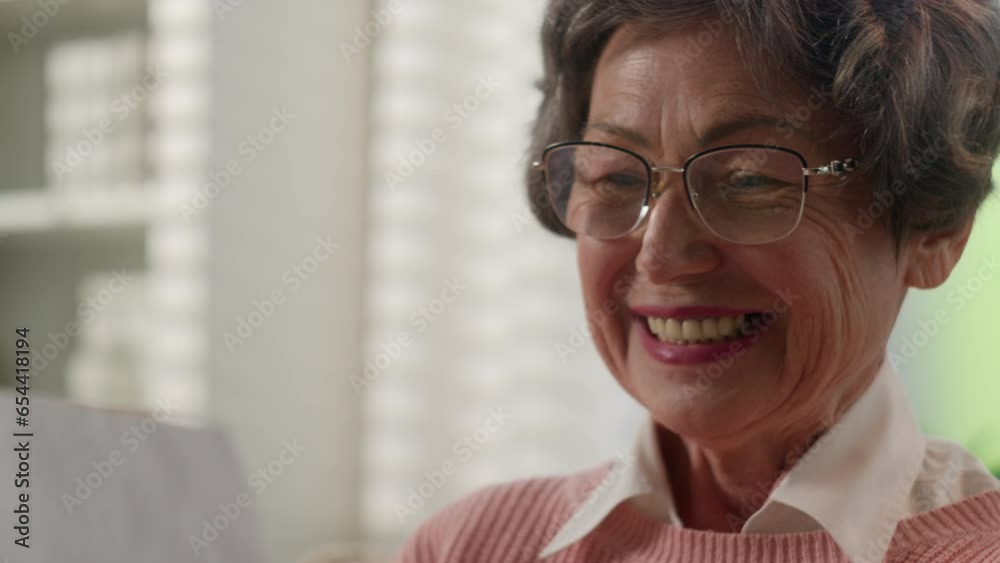 Happy smiling laughing joyful Caucasian old woman reading good news female retired lady senior granny mature grandmother read paper postal letter receive birthday card from family notice offer at home