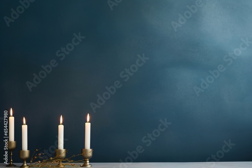 Hanukkah background with lit candles against gray blue wall backdrop
