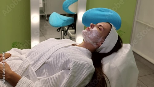 Cosmetologist applying cream with anesthesia on patient's face, portrait closeup view. Preparing skin for biorevitalization or thread lifting procedure. Woman in beauty clinic with doctor beautician.