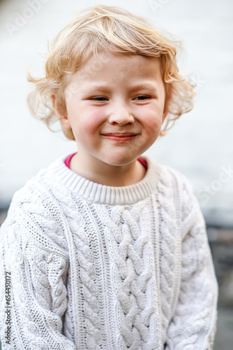 Photos Portrait of a smiling blonde girl on a light wall background
