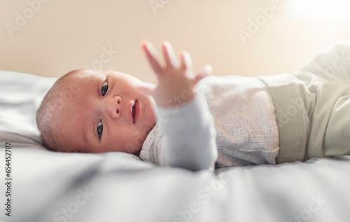 newborn baby in bedroom lying on white sheet