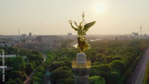 Establishing Aerial view of Berlin Skyline with Victory Column. Goldelse as tourist attraction and viewing platform. German Capital Skyline with Tiergarten park. 4K drone orbit panorama on sunrise photo