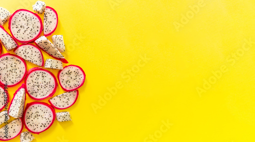 Slices of fresh white pitaya or dragon fruit on yellow background, flat lay