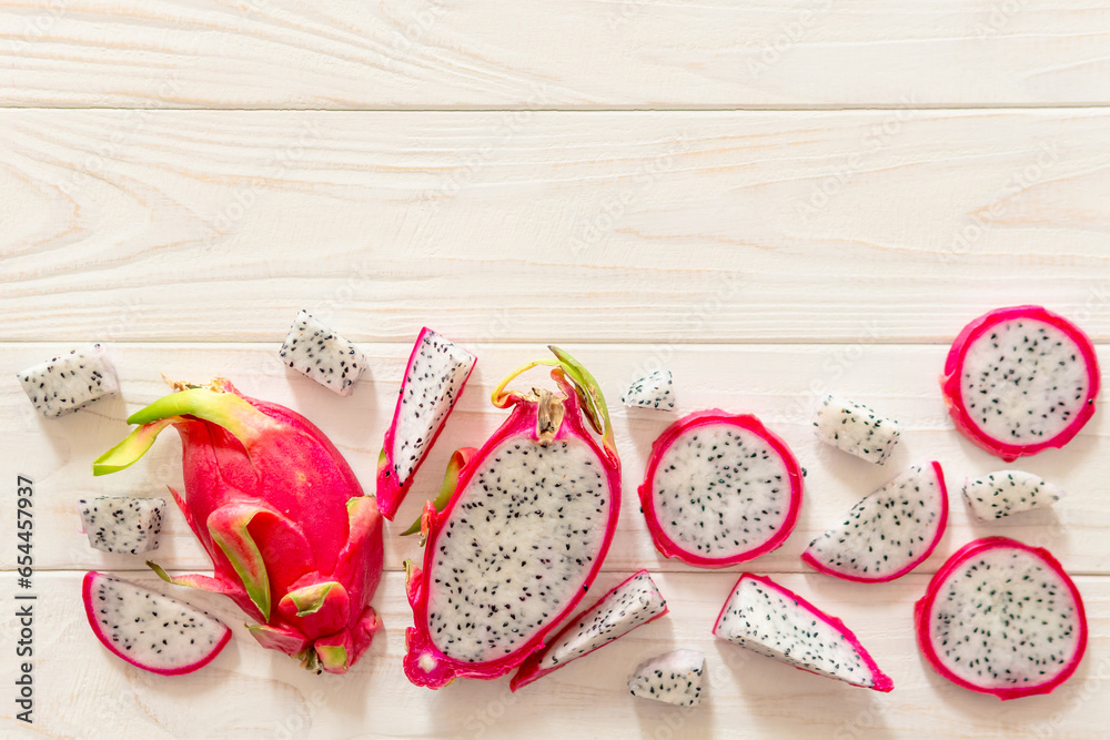 Slices of fresh white pitaya or dragon fruit on wooden background, top view Slices of fresh white pitaya or dragon fruit on wooden background, top view