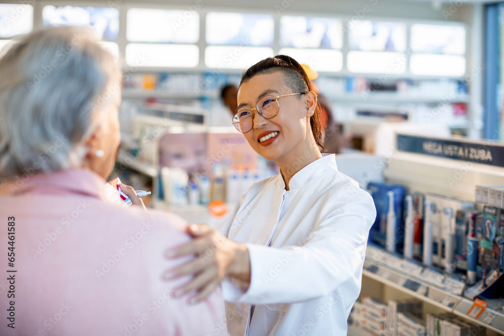 Young female pharmacist offering support to a customer about medication in a pharmacy Young female pharmacist offering support to a customer about medication in a pharmacy
