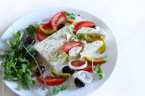 Insalata greca con formaggio feta e verdure fresche, sfondo bianco. Concetto di cucina greca. Cibo sano e vegetariano. Vista dall'alto. Copia spazio.