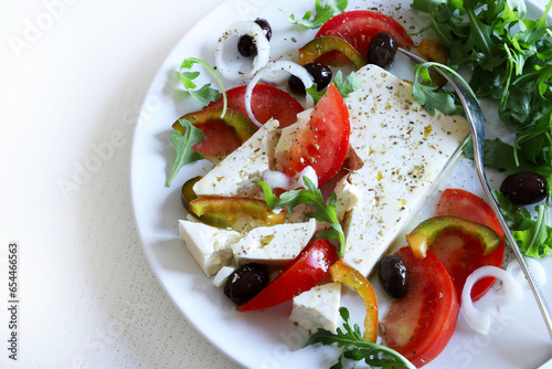 Insalata greca con formaggio feta e verdure fresche, sfondo bianco. Concetto di cucina greca. Cibo sano e vegetariano. Vista dall'alto. Copia spazio.