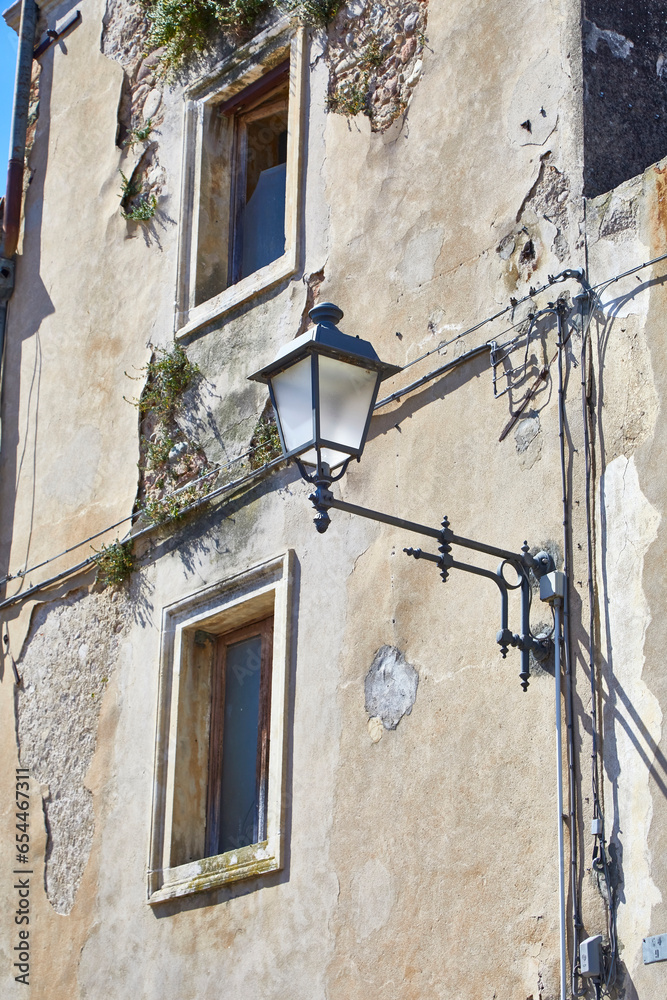 Old house wall in Tuscany, with a beautiful street lantern.