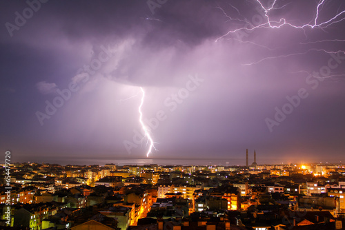 Lightning strikes over the city at night. 