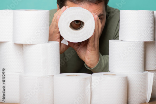 Man with a supply of toilet paper. Observation through a telescope made from a toilet paper roll.