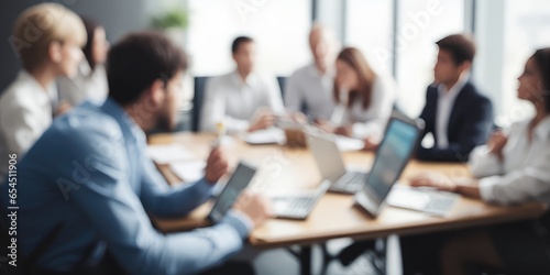 Business idea. People gathered at the table are softly blurred. Background of an abstract, blurred office interior. 