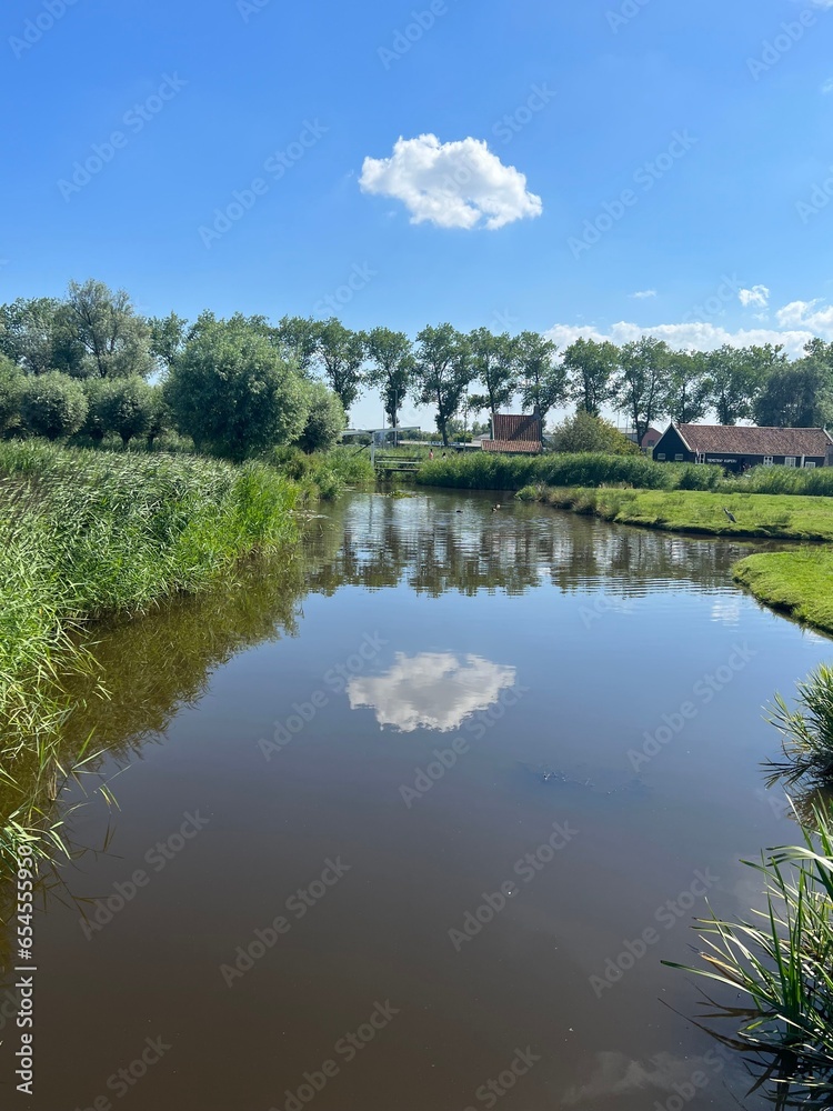 A river in the Netherlands with a reflection of a cloud