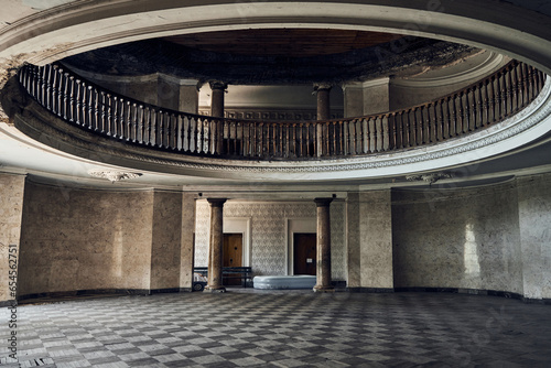 Abandoned soviet spa resort (sanatorium) Metallurg, in Tskaltubo, Georgia. Mezzanine floor, balcony with balusters. Columns on the background. Inflatable pool. Stalin empire style   photo