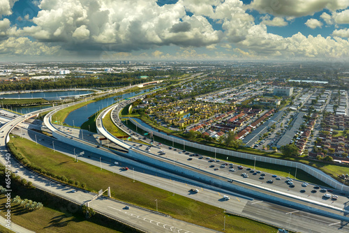 Aerial view of american freeway intersection with fast driving cars and trucks in Miami, Florida. View from above of USA transportation infrastructure