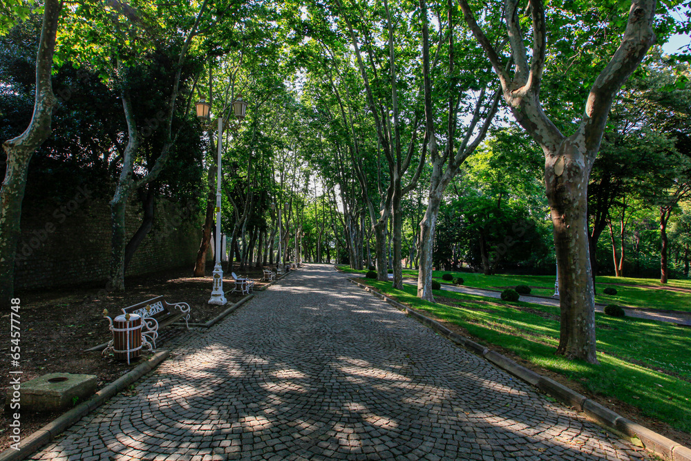 A park with cobblestone paved tree-lined paths